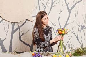 pretty florist making bouquet from spring flowers